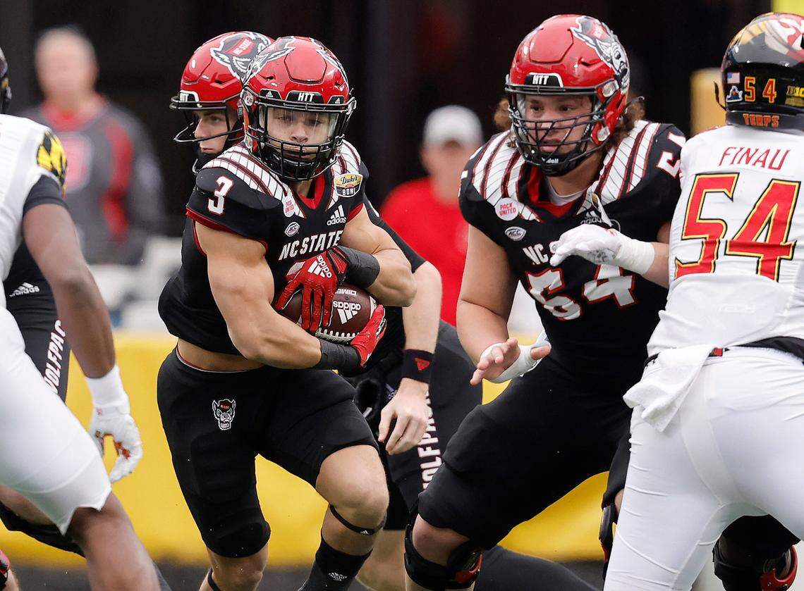 N.C. State offensive lineman Dylan McMahon (54) blocks for running back Jordan Houston (3) during the first half of N.C. State’s game against Maryland in the Duke’s Mayo Bowl at Bank of America Stadium in Charlotte, N.C., Friday, Dec. 30, 2022.