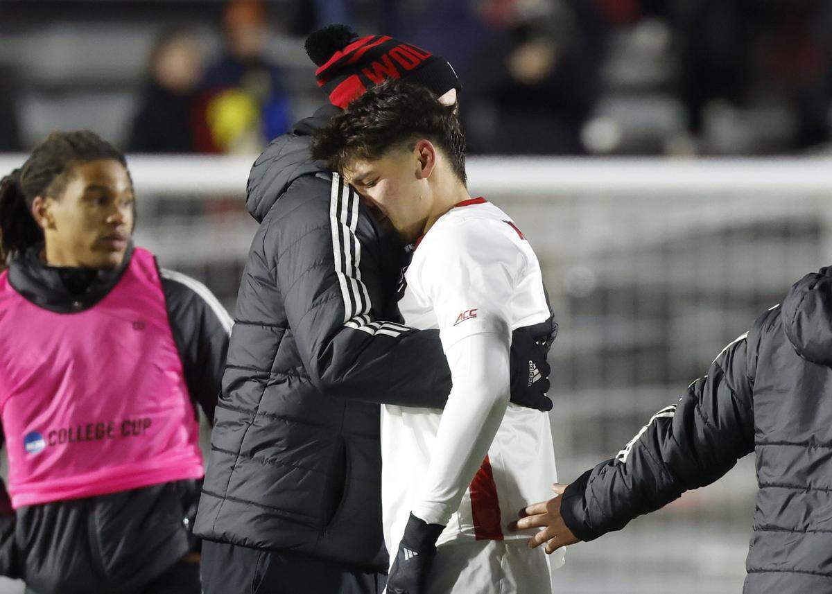 N.C. State's head coach Marc Hubbard consoles Justin McLean (8) after Washington’s 3-2 overtime victory over N.C. State in the 2025 Men’s Soccer National Championship at WakeMed Soccer Park in Cary, N.C., Monday, Dec. 15, 2025.