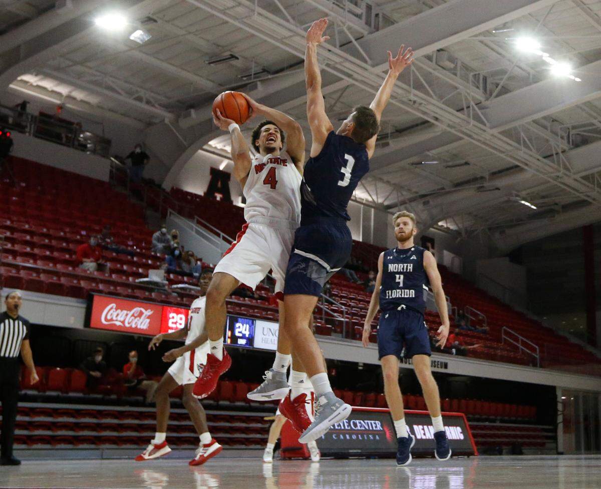 N.C. State’s Jericole Hellems (4) drives to the basket as North Florida’s Carter Hendricksen (3) defends during N.C. State’s 86-51 victory over North Florida in the Mako Medical Wolfpack Invitational at Reynolds Coliseum in Raleigh, N.C., Friday, Nov. 27, 2020.