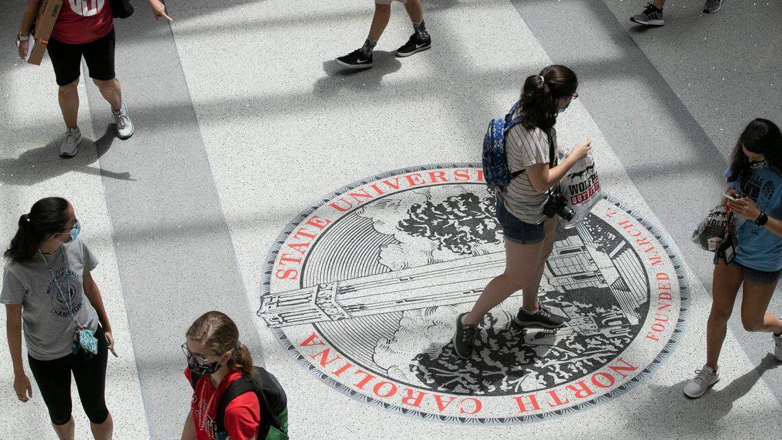 N.C. State University students step across the university logo inside the Talley Student Union on Thursday, August 6, 2020 in Raleigh, N.