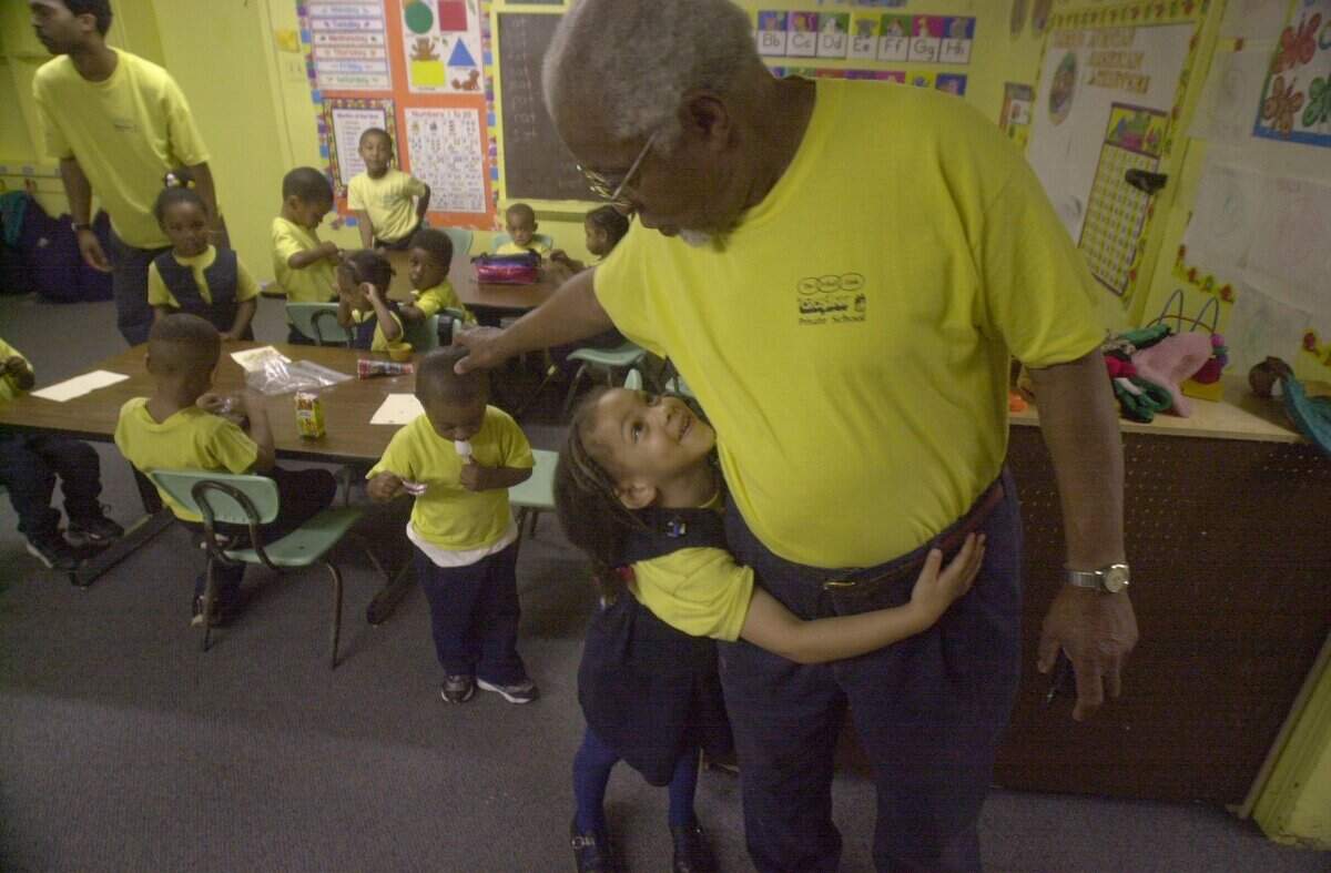 Kenneth Murray Muhammad, in this photo from 2001, can’t walk through his private school’s classrooms without getting hugs and affection from kids in every class. Here, Muhammad, owner/operator of the Vital Link Private School in west Raleigh gets a hug from then-4-year-old Vanessa Anderson. Muhammad started the school with his wife Margaret in 1964.