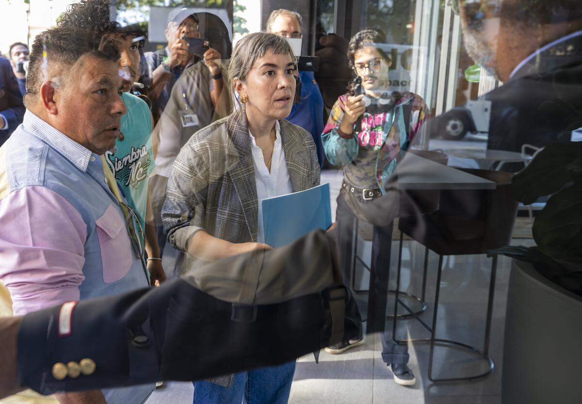 Nikki Marin Baena, with Siembra NC, and Duke University bus driver Luis Alonso Juárez, left, deliver a letter for Senator Ted Budd to the security guard at 333 Fayetteville Street on Thursday, September 4, 2025 in Raleigh, N.C. Juárez, is a Honduran immigrant that could face deportation. 