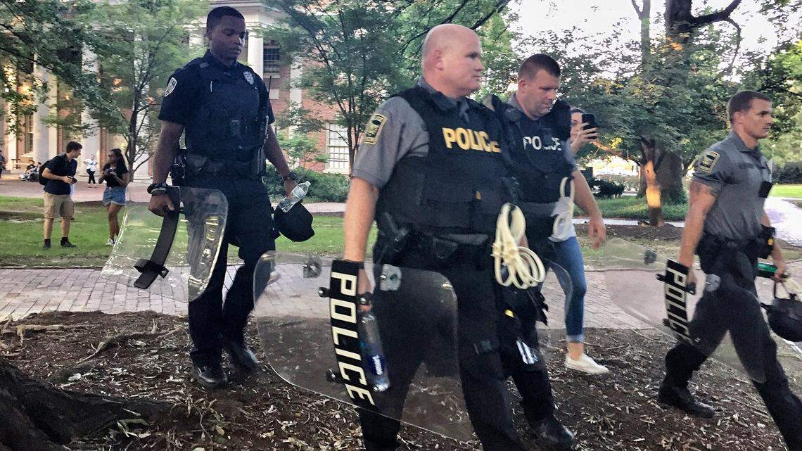 Police officers with riot gear converge near the site where Silent Sam formerly stood as UNC prepares for another night of protests and counter-protests Thursday, Aug. 30, 2018.