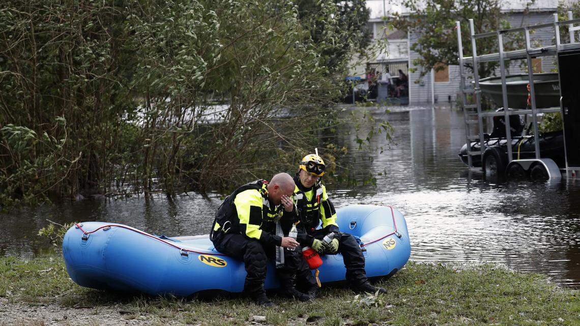 Members of a combined New Bern/Greenville swift water rescue team Brad Johnson, left, and Steve Williams rest after searching for people stranded by floodwaters caused by the tropical storm Florence in New Bern, N.C., on Saturday Sept. 15, 2018.