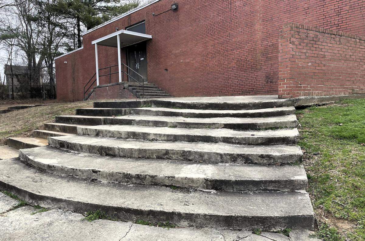 Concrete steps on one side of Hillsborough Elementary School are cracking and worn, creating an unstable footing.