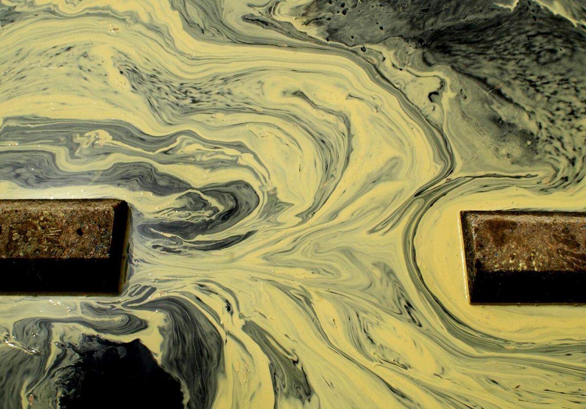 Mimicking an iridescent display of magnetic fields, pollen swirls around a parking lot in Durham after a morning shower in 2022.