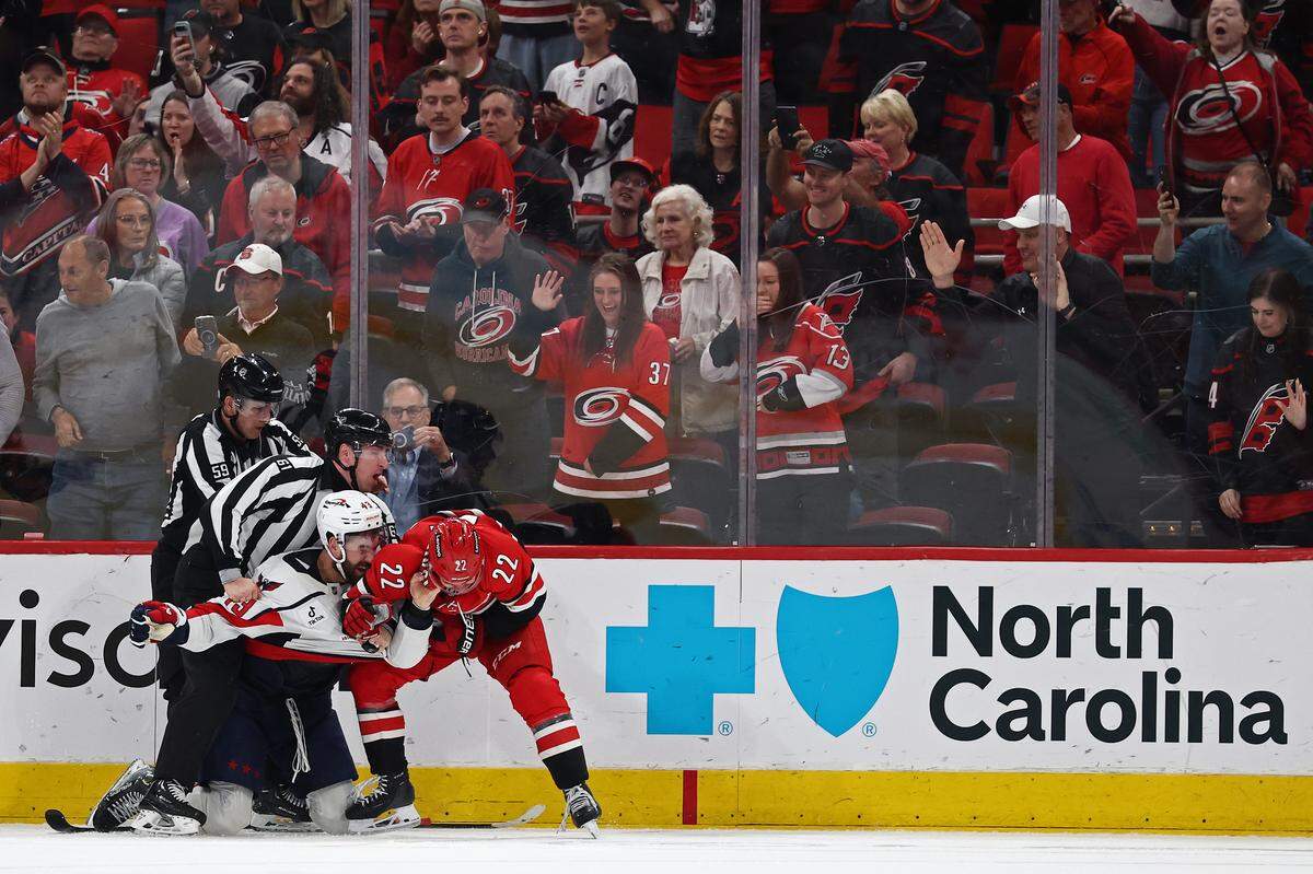 Logan Stankoven of the Carolina Hurricanes and Tom Wilson of the Washington Capitals fight during the third period of the game at Lenovo Center on April 2, 2025 in Raleigh, North Carolina.