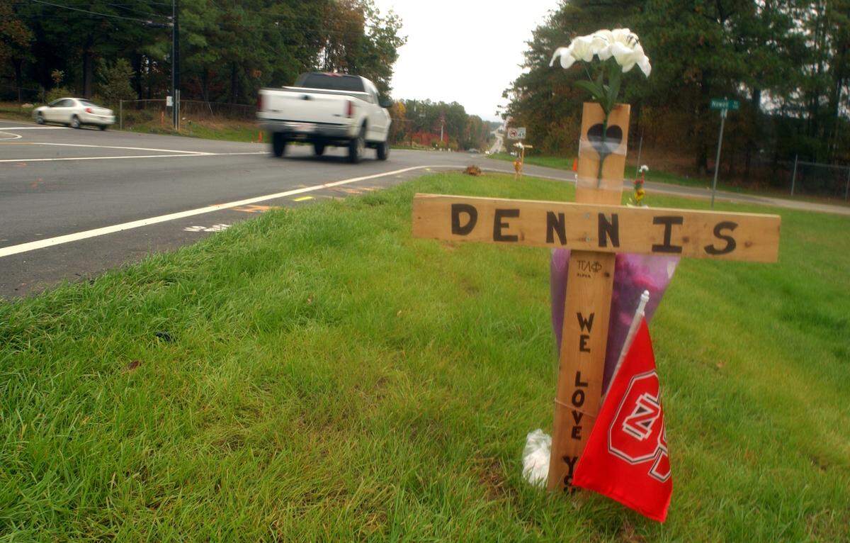 A memorial cross for Dennis Bowes sits on the side of Chapel Hill Road at the site of an accident that killed Bowes and five others who had stopped to help victims of another car accident in 2003.