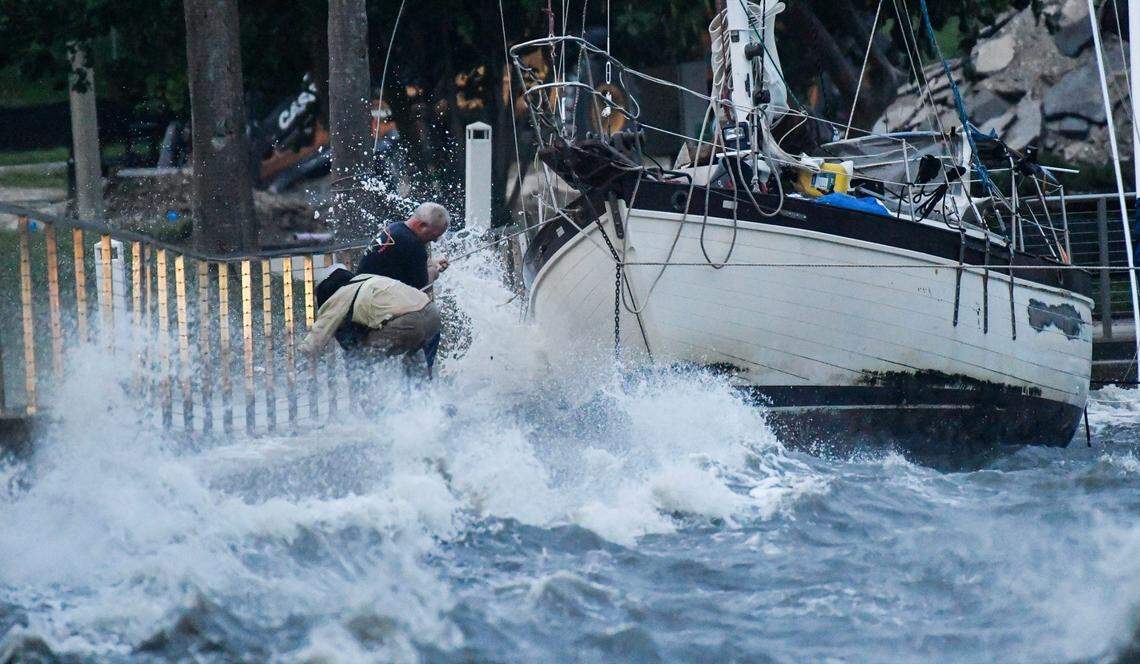 Two men brave the winds and heavy surf to try and secure a boat along the seawall in Cocoas Lee Wenner Park Thursday, September 26, 2024