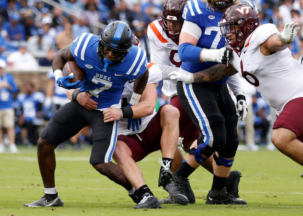 Duke Blue Devils running back Jordan Waters is brought down by Virginia Tech Hokies linebacker Dax Hollifield during the first half of a football game at Wallace Wade Stadium on Saturday, Nov. 12, 2022, in Durham, N.C.