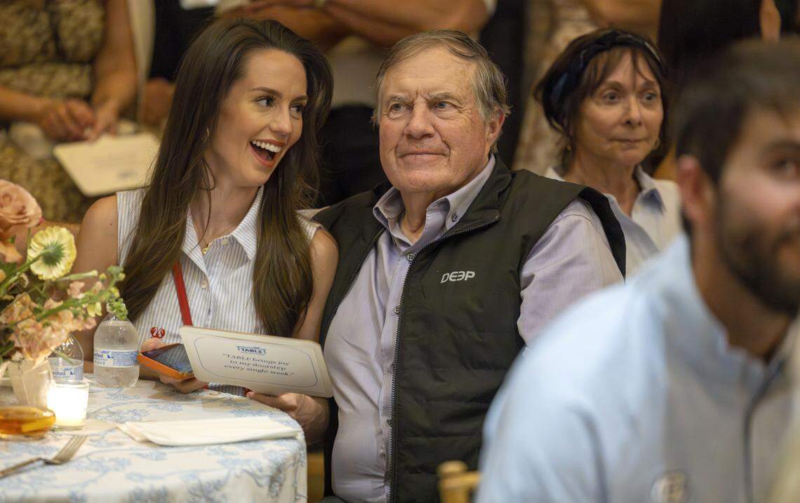 Jordan Hudson and North Carolina coach Bill Belichick participate in an auction fundraiser for TABLE, a nonprofit that addresses food insecurity among children and families in Orange County, on Friday, April 17, 2026, in Carrboro, N.C.