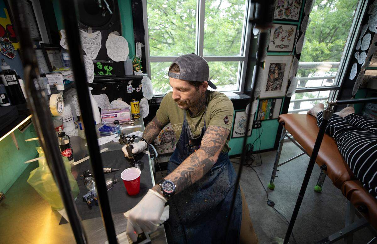 Mike Wheeler, owner of Easy Tiger Custom Tattoo in Durham, prepares to give a client a tattoo on Wednesday, June 21, 2023.