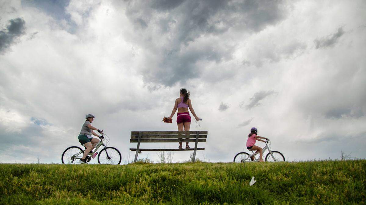 Anne Marie Romaine of Raleigh takes in the view from a bench as cyclists use the greenway.