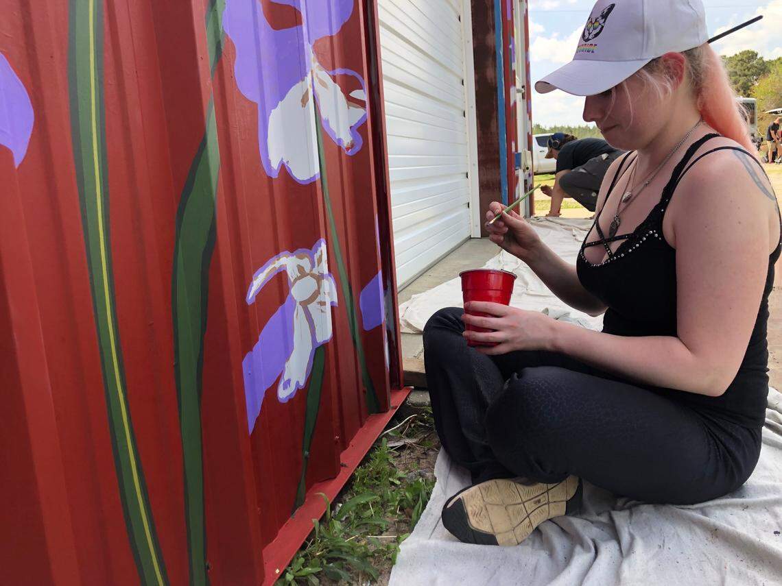Hollie Hewitt of Columbia volunteered to help Matt Willey and others paint a mural on the Red Wolf Center to highlight the critically endangered animals that live in the wild nowhere but Eastern NC.