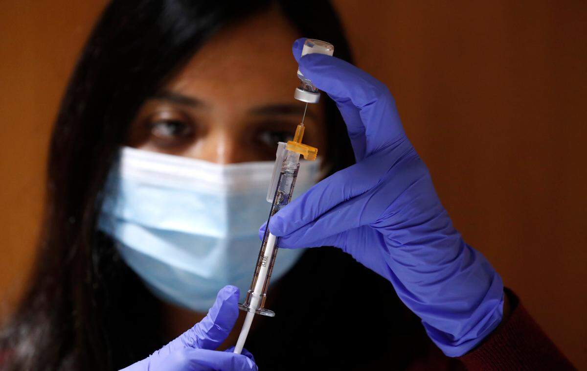 Pharmacy technician Susan Rozario withdraws a .3 ml dose of Pfizer’s COVID-19 vaccine during a COVID vaccine clinic for employees at UNC REX Healthcare at UNC Rex Hospital in Raleigh, N.C., Thursday, January 7, 2021.