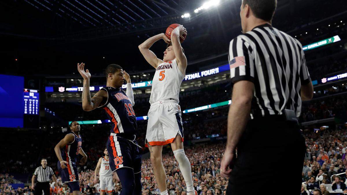 Virginia’s Kyle Guy (5) takes a shot as Auburn’s Samir Doughty (10) was called foul during the second half in the semifinals of the Final Four NCAA college basketball tournament, Saturday, April 6, 2019, in Minneapolis. (AP Photo/David J. Phillip)