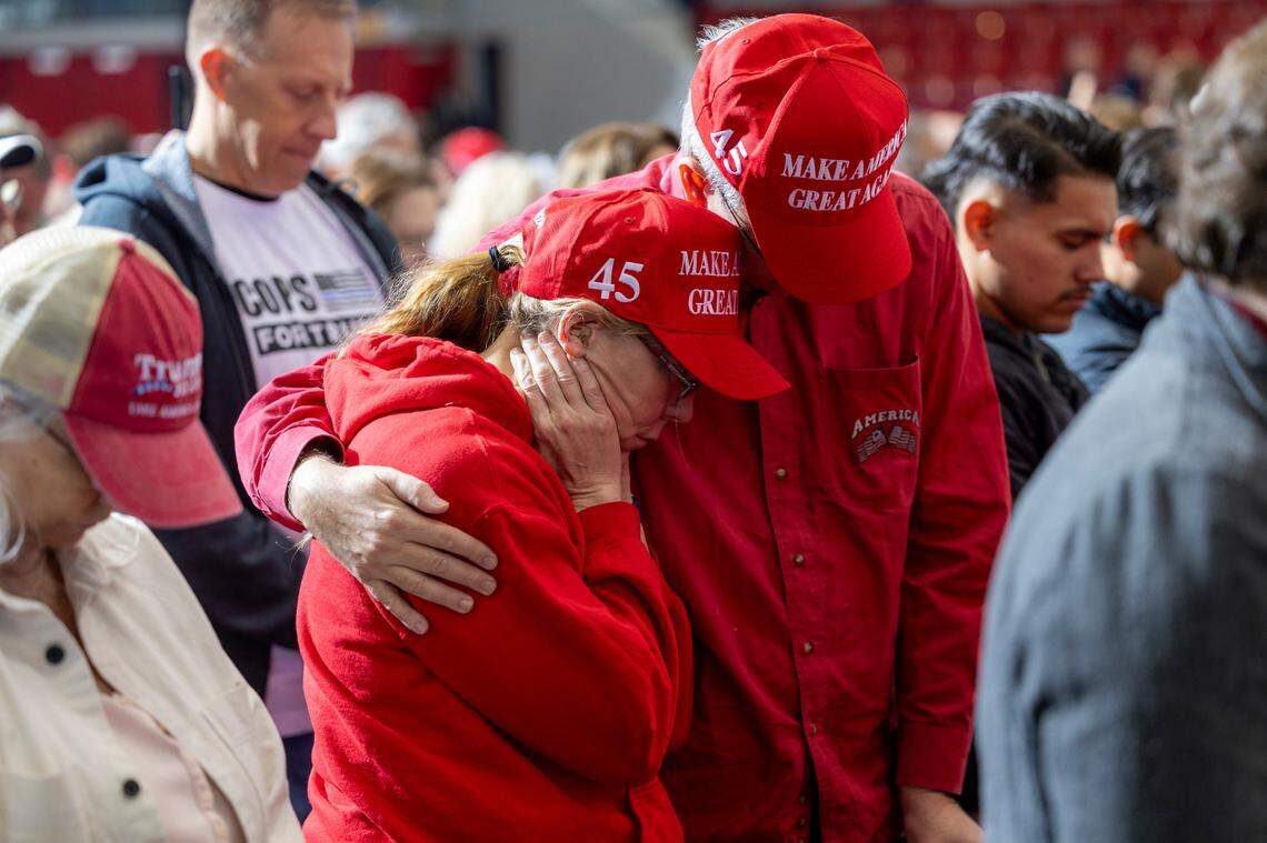 Supporters of Republican presidential nominee and former President Donald Trump pray during the invocation during a campaign rally at Dorton Arena in Raleigh on Monday, Nov. 4, 2024, one day before Election Day.