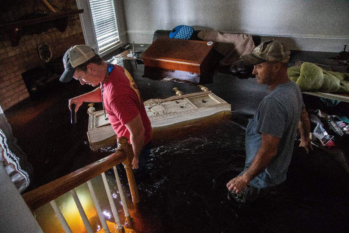 Mike Haddock, 48, right, and his stepson Justin Humphrey, 24, look for a family bible in Haddock’s flooded home on Monday, Sept. 17, 2018 in Trenton, NC following Hurricane Florence.