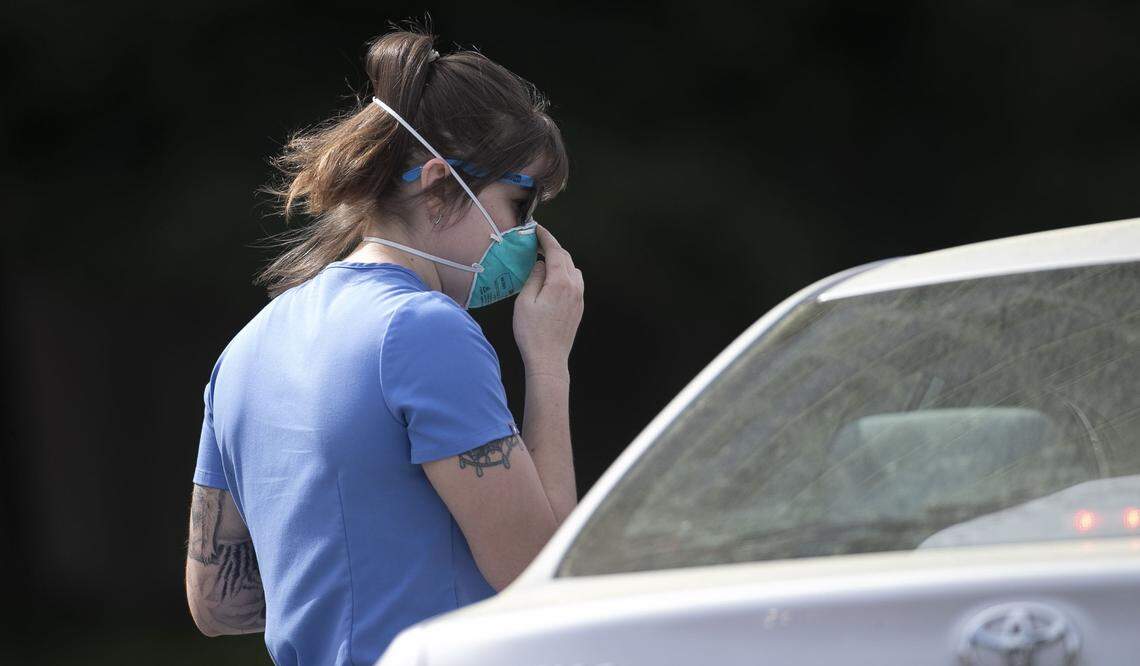 A UNC Hospitals employee screens visitors to the UNC Medical Center Emergency Department on Monday, March 30, 2020 in Chapel Hill, N.C. These screening procedures started about two weeks ago in an effort to prevent patients with respiratory symptoms of the COVID-19 virus from mixing with other patients in the emergency department.