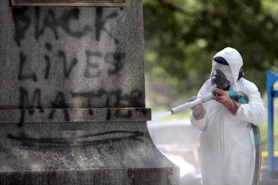 A worker blasts the sandstone base of the Silent Sam monument to remove spray-paint graffiti Tuesday, July 7, 2015.