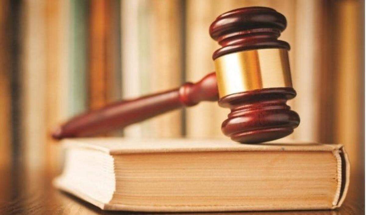 A judge’s gavel rests on a book of law.