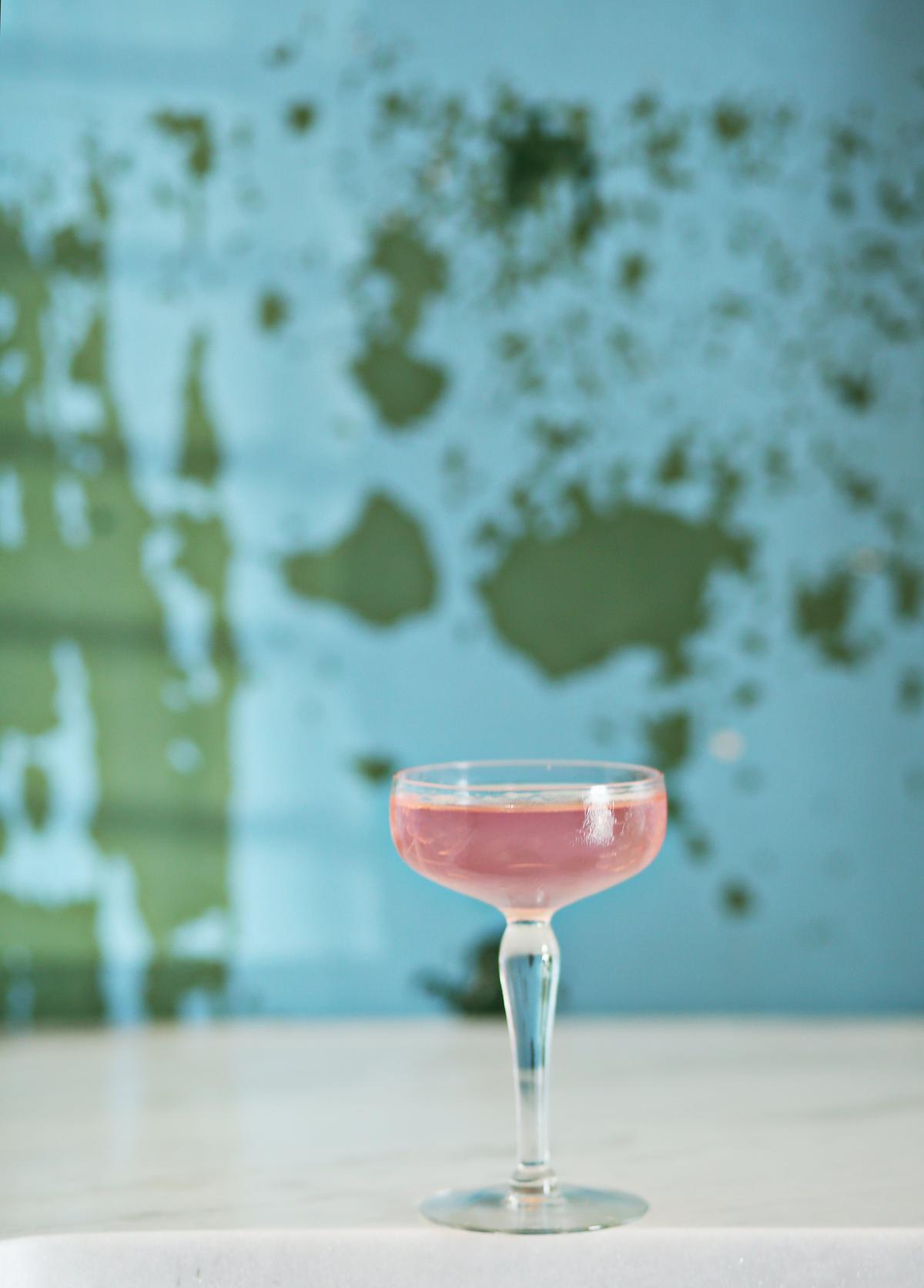The Petal Guru, an elegant riff on a martini made with equal parts Conniption gin and dry vermouth tinged a pale, translucent pink with a few drops of rosewater and garnished with a rose petal.