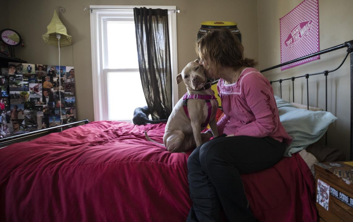 Susan Plattner kisses her dog Maya in her son Caleb Mehlman's room on March 16, 2018. Caleb, a graduate of Leesville Road High School, passed away from an overdose involving Xanax, a drug he took frequently, on December 19, 2017, his 19th birthday. "They know," Plattner says of her dog. "She just senses if I'm upset and comes right over to me."