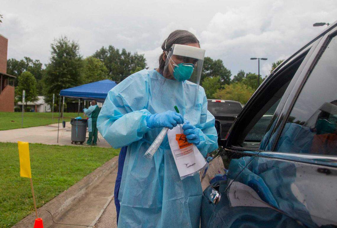 Dr. Viviana Martinez-Bianchi takes a test swab at the drive-up COVID testing site at Holton Wellness Center in Durham.