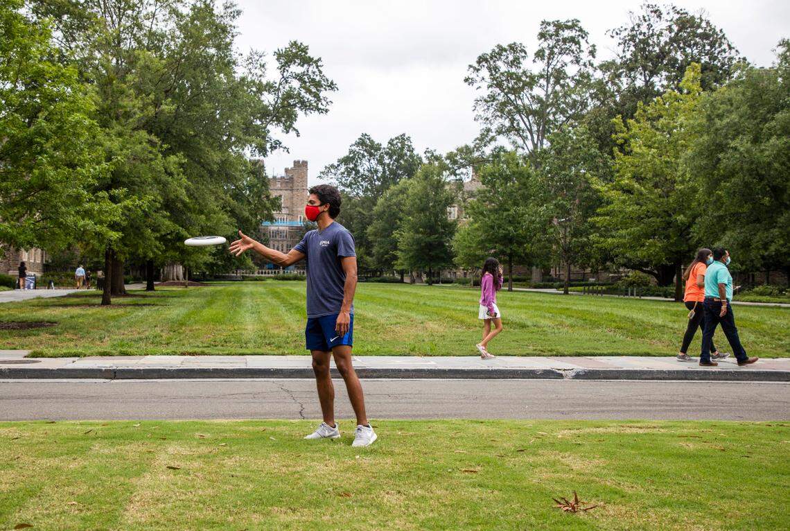 Wearing a mask to prevent the spread of COVID-19, Nick Reddy plays frisbee with friend Zach Glassband on the lawn in front of Duke Chapel during their first years at Duke University on Tuesday, Sept. 1, 2020, in Durham, N.C.