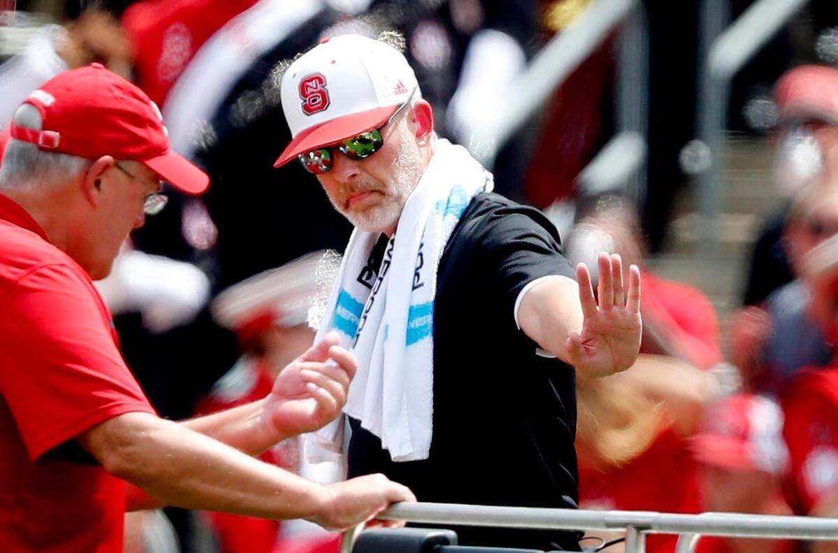 Rob Murphy (center in white hat), who was listed as an associate athletic director and director of sports medicine at N.C. State, helps a crew move an injured football player in the first half of N.C. State’s game against JMU at Carter-Finley Stadium in Raleigh, N.C., Saturday, Sept. 1, 2018.