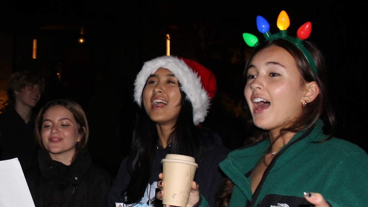Enloe High School students, from left to right, Sofia Pellegrino, Jiya Shu Bhure and Penny Choy sing Christmas carols on Williamsborough Court in Raleigh on Dec. 11, 2023 to raise money for the 2023 Enloe Charity Ball.