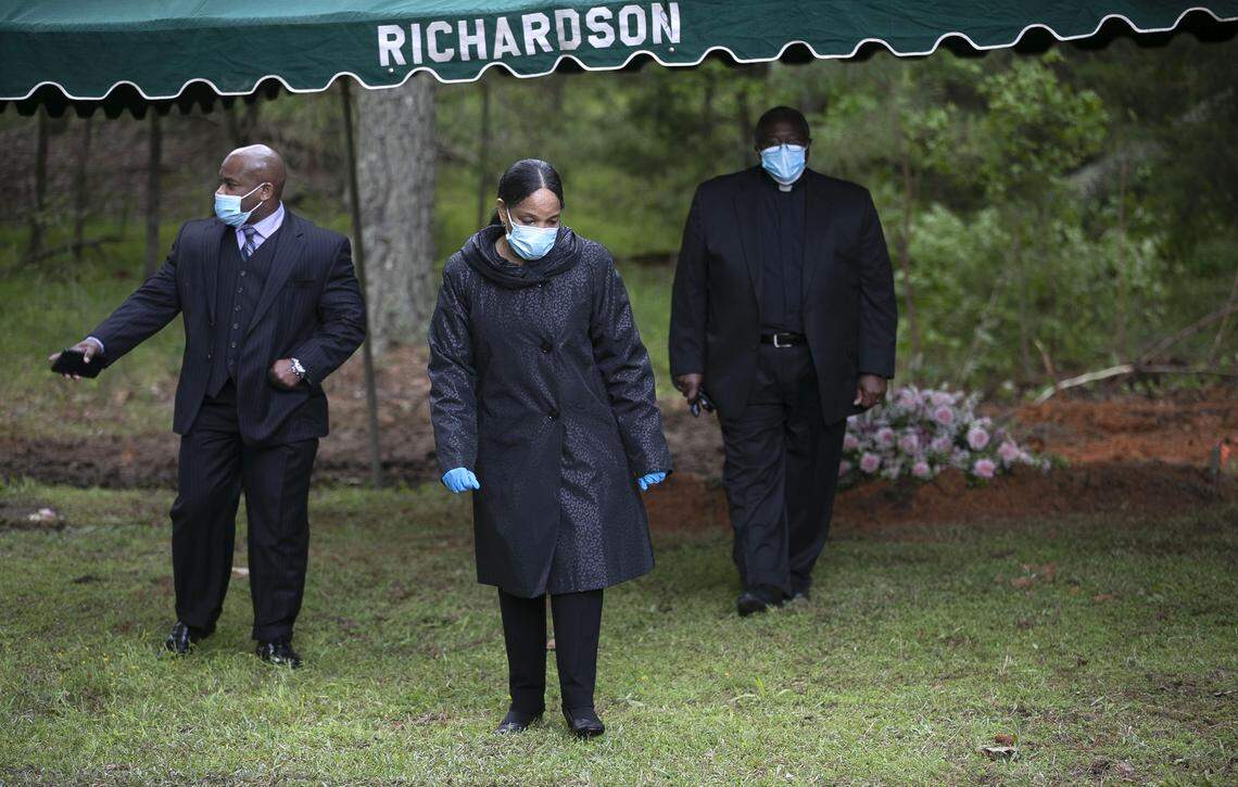 Ernestine Keith, center, her husband Pastor Larry Keith and son Matthew Keith leave the grave of Ernestine’s mother Cleora W. Mann after a final viewing on Friday, May 1, 2020 in Louisburg, N.C. Cleora W. Mann, age 104, died from the coronavirus virus on Sunday, April 26. She was a resident of Louisburg Healthcare & Rehabilitation Center where 62 positive cases and 18 deaths from the coronavirus were reported by the Franklin County Health Department.