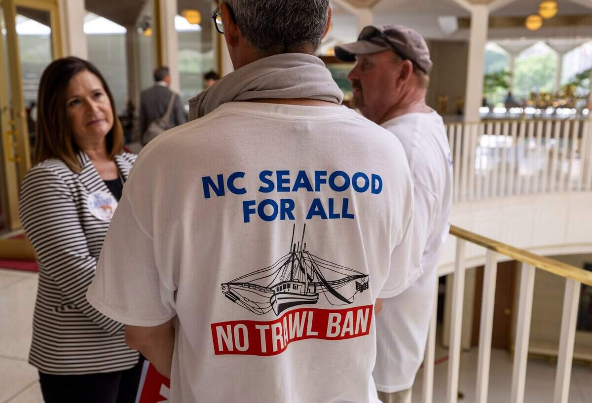 Rep. Celeste Cairns, who represents Carteret County, talks with shrimpers Larry Kellum Jr. and Kenny Rustic outside the House chamber on Tuesday, June 24, 2025 in Raleigh, N.C. Kellum and Rustic were among the hundreds of fishing industry employees working to stop HB 442, which would ban shrimp trawling in all inshore fishing waters and within one-half mile of the shoreline.
