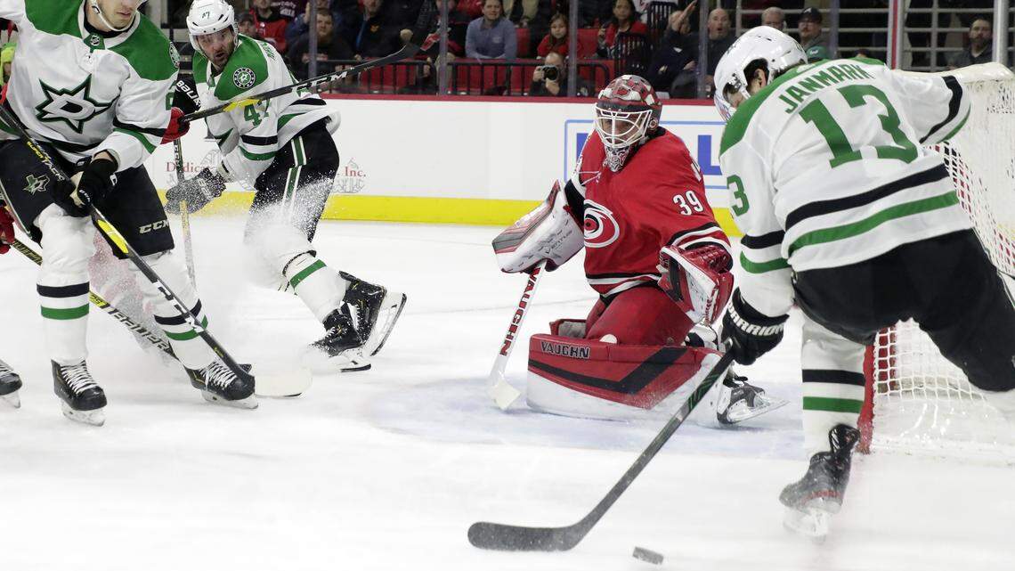 Carolina Hurricanes’ Alex Nedeljkovic (39) defends the net against Dallas Stars’ Jamie Oleksiak (2) and Mattias Janmark (13) during the first period of an NHL hockey game in Raleigh, N.C. (AP Photo/Chris Seward)