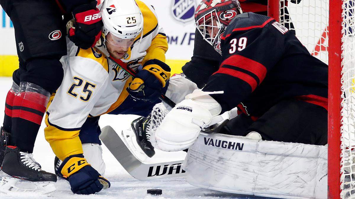 Carolina Hurricanes goaltender Alex Nedeljkovic (39) prepares to cover the puck in front of Nashville Predators’ Mathieu Olivier (25) during the first period of an NHL hockey game in Raleigh, N.C., Tuesday, March 9, 2021. (AP Photo/Karl B DeBlaker)