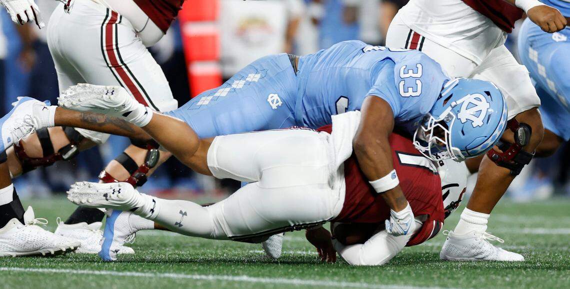 North Carolina linebacker Cedric Gray (33) tackles South Carolina quarterback Spencer Rattler (7) during the first half of UNC’s game against South Carolina in the Duke’s Mayo Classic at Bank of America Stadium in Charlotte, N.C., Saturday, Sept. 2, 2023.