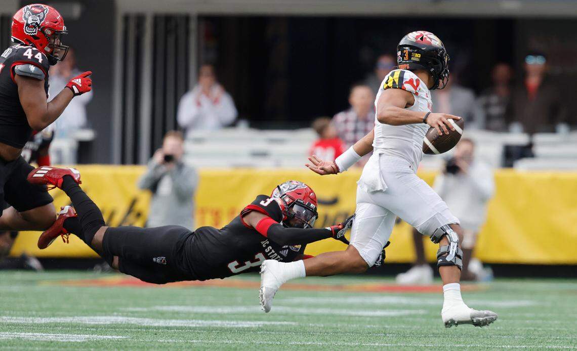 Maryland quarterback Taulia Tagovailoa (3) tries to escape from N.C. State cornerback Aydan White (3) during the second half of Maryland’s 16-12 victory over N.C. State in the Duke’s Mayo Bowl at Bank of America Stadium in Charlotte, N.C., Friday, Dec. 30, 2022.