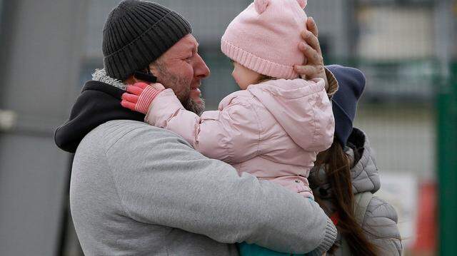 A father hugs his daughter as the family reunite after fleeing conflict in Ukraine, at the Medyka border crossing, in Poland, Sunday, Feb. 27, 2022. Since Russia launched its offensive on Ukraine, more than 200,000 people have been forced to flee the country to bordering nations like Romania, Poland, Hungary, Moldova, and the Czech Republic, in what the U.N. refugee agency, UNHCR, said will have “devastating humanitarian consequences” on civilians.