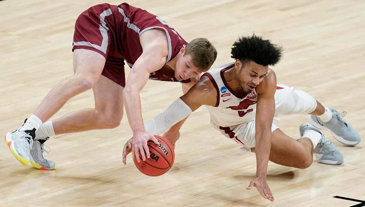 Colgate’s Tucker Richardson (15) and Arkansas’ Justin Smith (0) dive for a loose ball during the second half of a first round game at Bankers Life Fieldhouse in the NCAA men’s college basketball tournament, Friday, March 19, 2021, in Indianapolis. (AP Photo/Darron Cummings)