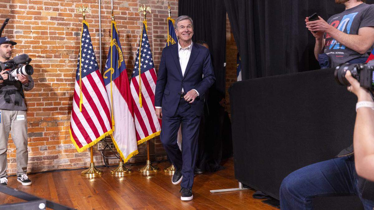 Former Gov. Roy Cooper takes the stage during a “Make Stuff Cost Less” campaign rally on April 9, 2026, at Bay 7 in Durham’s American Tobacco Campus. Cooper faces former Republican National Committee Chairman Michael Whatley in the race for U.S. Senate. Both are vying to replace Sen. Thom Tillis, a Republican from Huntersville, who is retiring at the end of his term.