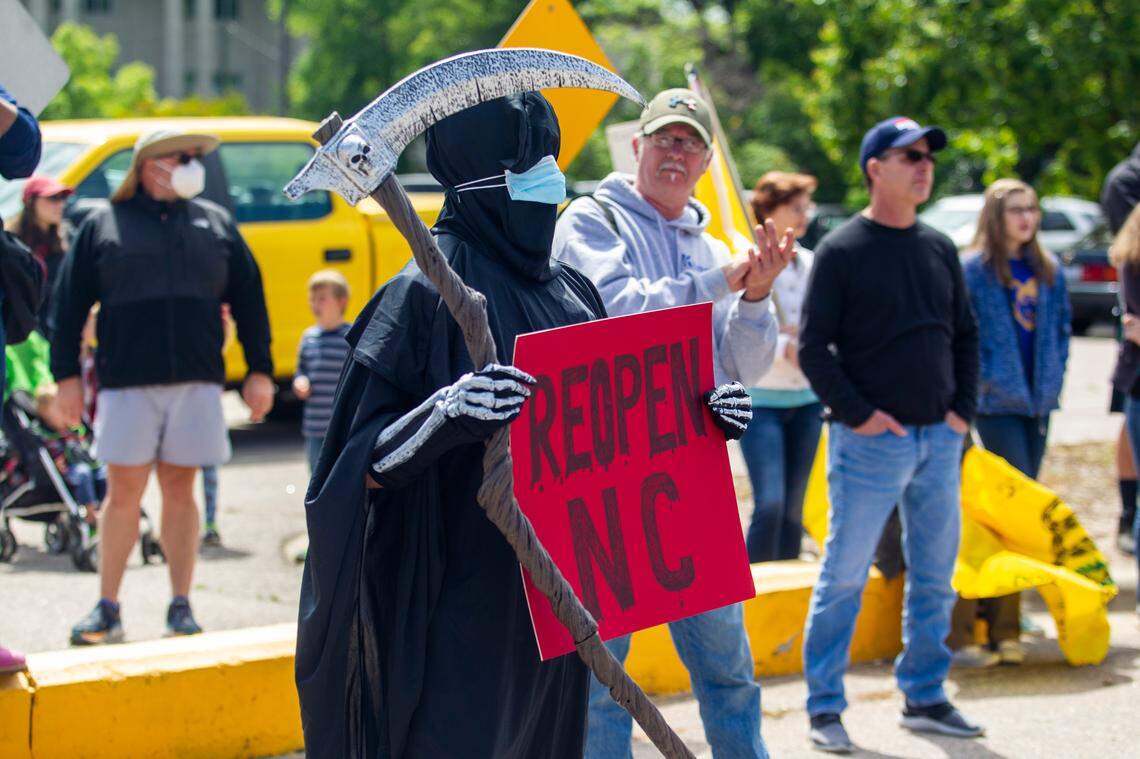 A person dressed as the Grim Reaper counter protests during a ReOpen NC rally in downtown Raleigh Tuesday, May 12, 2020.
