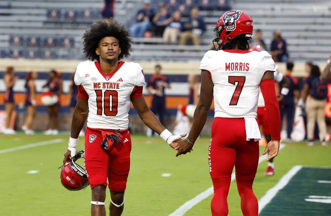 N.C. State quarterback MJ Morris (7) and wide receiver KC Concepcion (10) greet each other before the Wolfpack’s game against Virginia at Scott Stadium in Charlottesville, Va., Friday, Sept. 22, 2023.