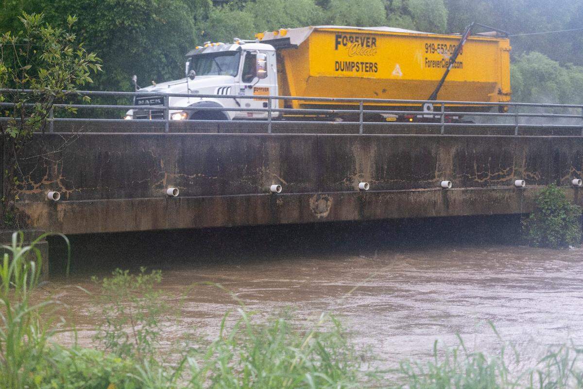 A swollen Walnut Creek continues to rise beneath the bridge on Garner Road, as heavy rain from Tropical Storm Debby moves into the area on Thursday, August 8, 2024 in Raleigh, N.C.