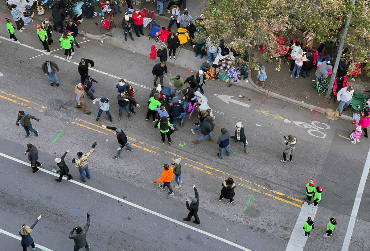 People rush to attempt to aid the victim, a young member of a dance troupe, after she was struck by a truck pulling a float of other dancers during the Raleigh Christmas Parade, Sunday, Nov. 19, 2022.