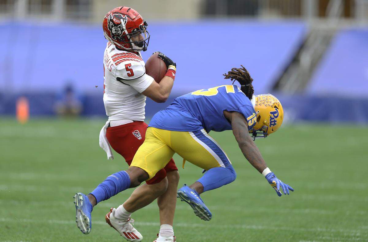 N.C. State’s Thayer Thomas (5) runs through a tackle attempt by Pittsburgh Panthers defensive back Jason Pinnock (15) after a catch during the Wolfpack’s victory over the Panthers at Heinz Field in Pittsburgh, PA, Saturday, Oct. 3, 2020.