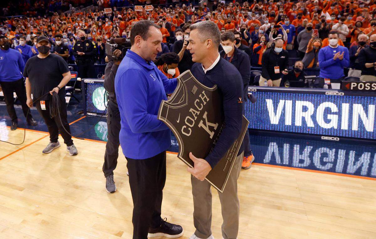Duke head coach Mike Krzyzewski gets a plaque from Virginia head coach Tony Bennett before Duke’s game against Virginia at John Paul Jones Arena in Charlottesville, VA, Wednesday, Feb. 23, 2022.
