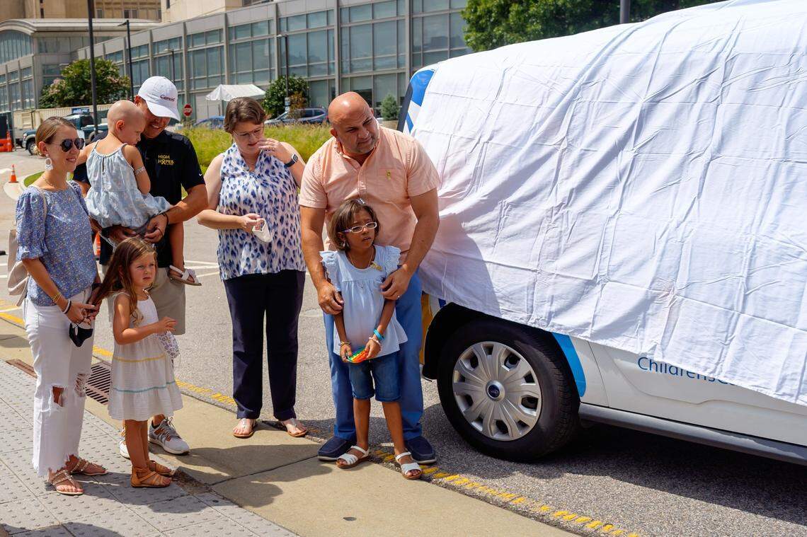 Families who have participated CCP program standing by the side of the new van to be unveiled.