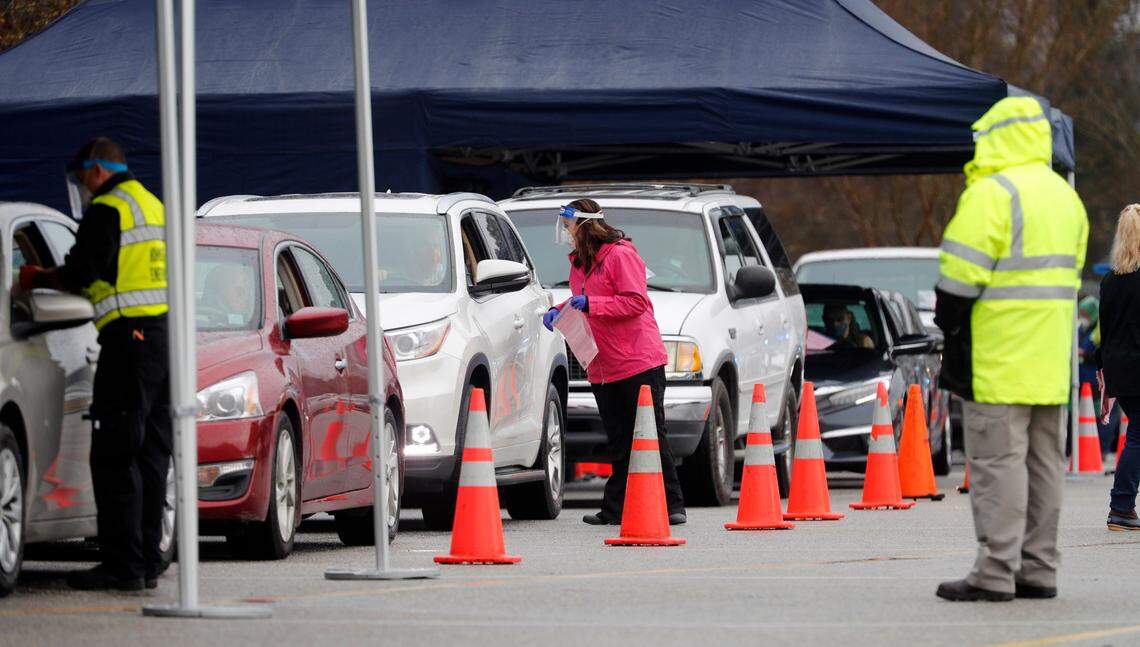 Information is taken from drivers and passengers in line to get their COVID vaccine shot during a drive-thru COVID vaccination clinic at West Johnston High School in Benson, N.C., Tuesday, January 12, 2021. The Johnston County Health Department clinic was for anyone 75 and older and was offered first come, first served for the first 500 who arrived.