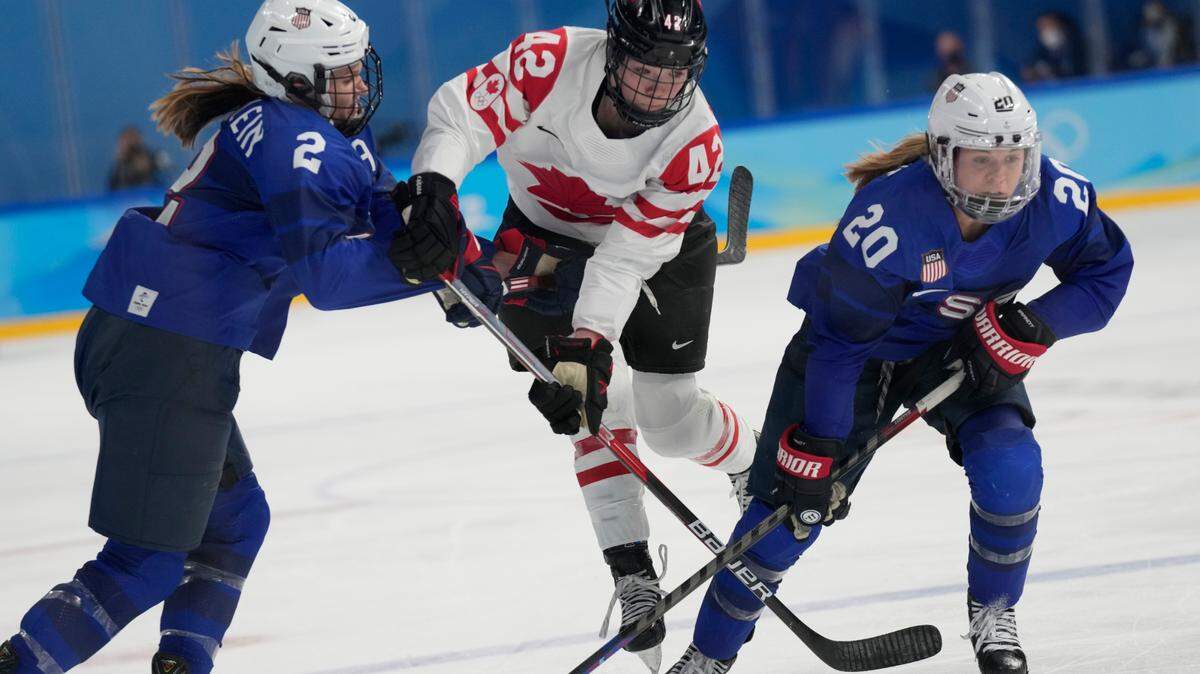 Canada’s Claire Thompson (42) tries to get past United States’ Lee Stecklein (2) and Hannah Brandt (20) during a preliminary round women’s hockey game at the 2022 Winter Olympics, Tuesday, Feb. 8, 2022, in Beijing. (AP Photo/Petr David Josek)