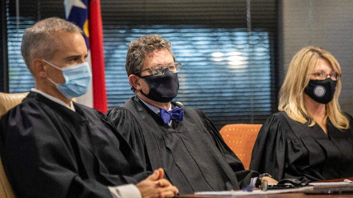 From left, Superior Court Judges Nathaniel Poovey, Graham Shirley and Dawn Layton listen to testimony from Jowei Chen, a political scientist from the University of Michigan, not pictured, during a partisan gerrymandering trial over North Carolina’s new political maps Monday, Jan. 3, 2022 at a courtroom at Campbell University School of Law in Raleigh in Raleigh, NC.